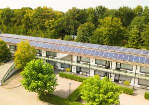 an image of a building with solar panels on it at Van der Valk Hotel Nuland - 's-Hertogenbosch in Nuland