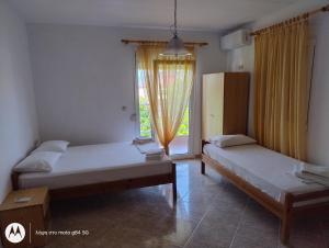 two beds in a room with a window at Catalina studios 2 in Olympic Beach
