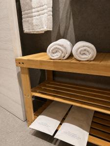 a wooden shelf with towels on it in a bathroom at Residenza Ricci in Azzano San Paolo +42 photos