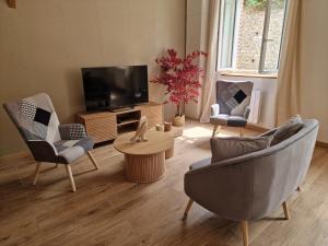 a living room with two chairs and a television at Cap Ouest in Fécamp