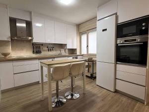 a kitchen with a table with two chairs and a refrigerator at Placituela 7 in San Esteban de Gormaz