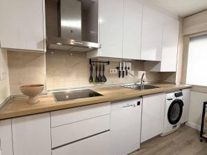 a white kitchen with a sink and a dishwasher at Placituela 7 in San Esteban de Gormaz +12 photos