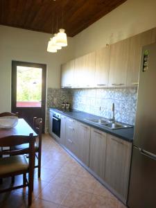 a kitchen with wooden cabinets and a sink and a table at John & Mary's House near Elafonisi Beach in Perivólia +29 photos
