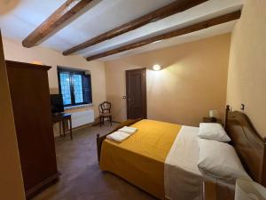 a bedroom with a bed and a desk and a television at Casolare La Mirabella 