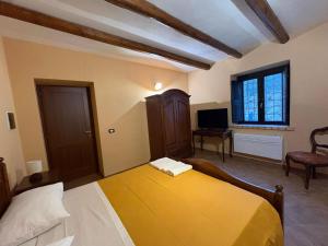 a bedroom with a yellow bed and a television at Casolare La Mirabella 