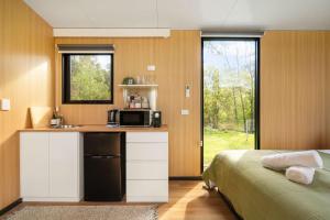 a kitchen with a microwave and a bed in a room at The Wollombi Wanderer by Tiny Away in Wollombi