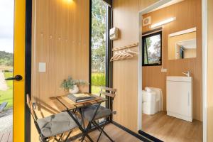 a tiny house with a table and a window at The Wollombi Wanderer by Tiny Away in Wollombi