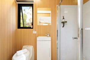 a bathroom with a white toilet and a window at The Wollombi Wanderer by Tiny Away in Wollombi