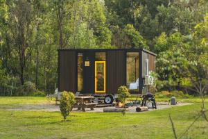a tiny house in a park with a picnic table at The Wollombi Wanderer by Tiny Away in Wollombi +19 photos