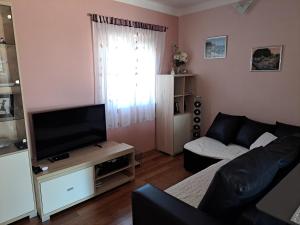 a living room with a couch and a flat screen tv at Villa Senka in Nečujam