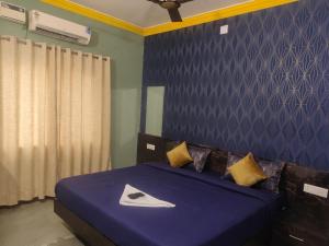 a bedroom with a bed with a blue blanket and yellow pillows at FabHotels Divo in Chennai