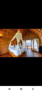 a bedroom with a bed with a mosquito net at Suwehan Blue Ocean Cliff in Semarapura