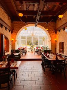 a restaurant with tables and chairs and a large window at Hotel St. Paulushof in Niedermohr