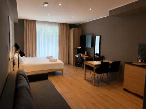 a hotel room with a bed and a table and a desk at Residenza Ricci in Azzano San Paolo