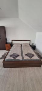 a bed with two pillows on it in a room at STUDIO Apartman in Gheorgheni