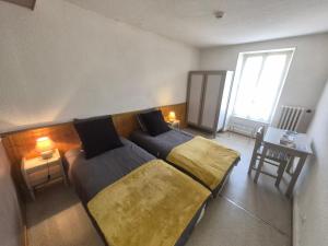 a bedroom with a bed and a table and a window at Auberge du sichon in Ferrières-sur-Sichon