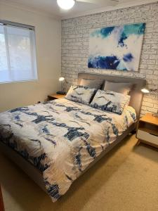 a bedroom with a bed and a painting on the wall at NR 4 Cove Apartment Carrickalinga in Carrickalinga