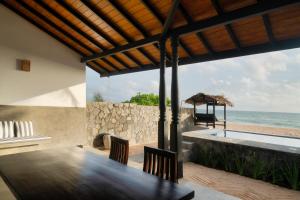 a dining room with a table and a view of the ocean at Blue Parrot Beach Villa with privat swimming pool in Ambalangoda