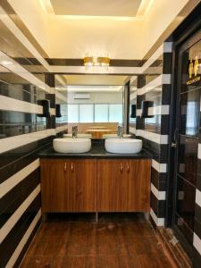 two sinks in a bathroom with black and white stripes at Hotel Shiny Grand in Guwahati