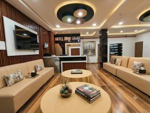 a living room with couches and tables and a fireplace at Hotel Shiny Grand in Guwahati
