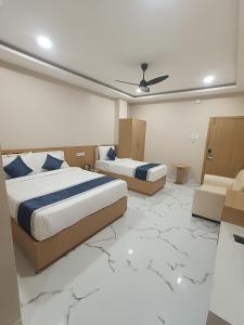 two beds in a room with a marble floor at Hotel Shiny Grand in Guwahati +35 photos