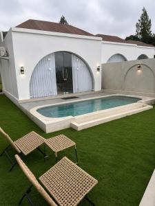 a house with a swimming pool and two chairs at Montelago Batur in Bangli