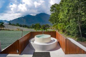 a hot tub on the deck of a house at Montelago Batur in Bangli