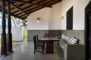 a dining room with a wooden table and chairs at Blue Parrot Beach Villa with privat swimming pool in Ambalangoda