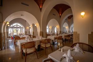 a dining room with white tables and chairs at Shams Alam Beach Resort in Marsa Alam City