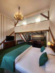 a large bedroom with a large bed and a chandelier at City Hotel Morris in Česká Lípa