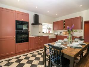 a kitchen with red cabinets and a wooden table at Evansford in Ballater