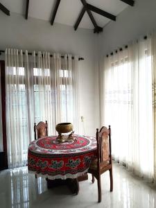 a room with a table and chairs and windows at Ciao Villa, Kandy in Kandy +37 photos