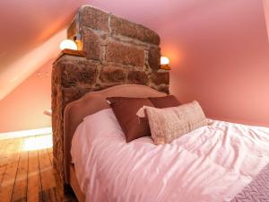 a bedroom with a bed with a brick wall at Evansford in Ballater