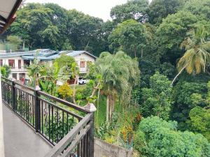 a balcony with a view of a house and trees at Ciao Villa, Kandy in Kandy