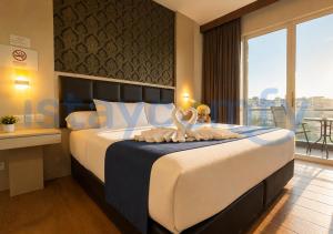 a hotel room with a bed with swans on it at Studio Aston Residence 0306 City View in Nagoya +6 photos
