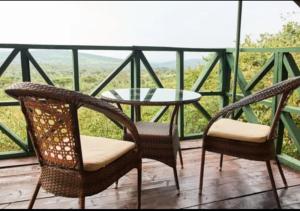 a patio with a table and two chairs and a table at La Maison Mara in Ololaimutiek