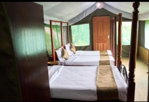 a bedroom with two beds in a tent at La Maison Mara in Ololaimutiek