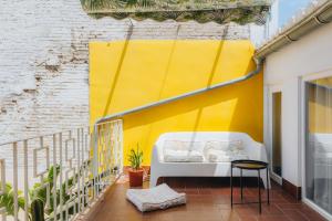 a balcony with a white bench and a yellow wall at La Casona Beach House in Valencia