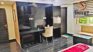 a room with a bar with a chair and a tv at hotel shivay in Basti