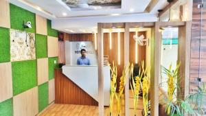 a man standing at a counter in a lobby at hotel shivay in Basti