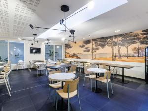 a restaurant with tables and chairs and a painting on the wall at Adagio Nice Centre in Nice