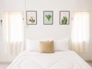 ein Schlafzimmer mit einem weißen Bett und vier Bildern an der Wand in der Unterkunft Seamsak hotel in Golden Triangle