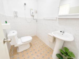 ein Badezimmer mit weißer Toilette und Waschbecken in der Unterkunft Seamsak hotel in Golden Triangle + 37 Fotos