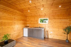 a kitchen in a wooden room with a sink at The Cabin in Mountfield +17 photos