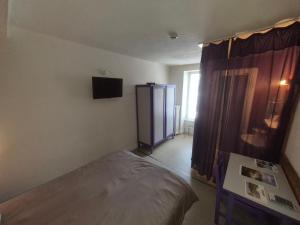 a room with a bed and a cabinet in it at Auberge du sichon in Ferrières-sur-Sichon