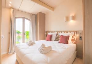 a bedroom with a large white bed with towels on it at Casa Liana Saint-Tropez in Saint-Tropez