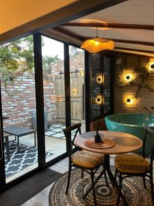 a patio with a table and chairs and a tub at Nest-Dove's Nest in Howick