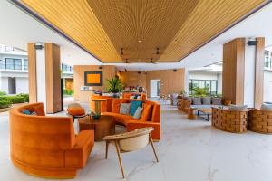 an open lobby with orange chairs and tables at Radisson Resort Layan Phuket in Layan Beach
