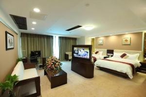 a hotel room with a bed and a flat screen tv at New World Hotel in Guangzhou