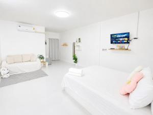 ein weißes Wohnzimmer mit einem Bett und einem Sofa in der Unterkunft Seamsak hotel in Golden Triangle